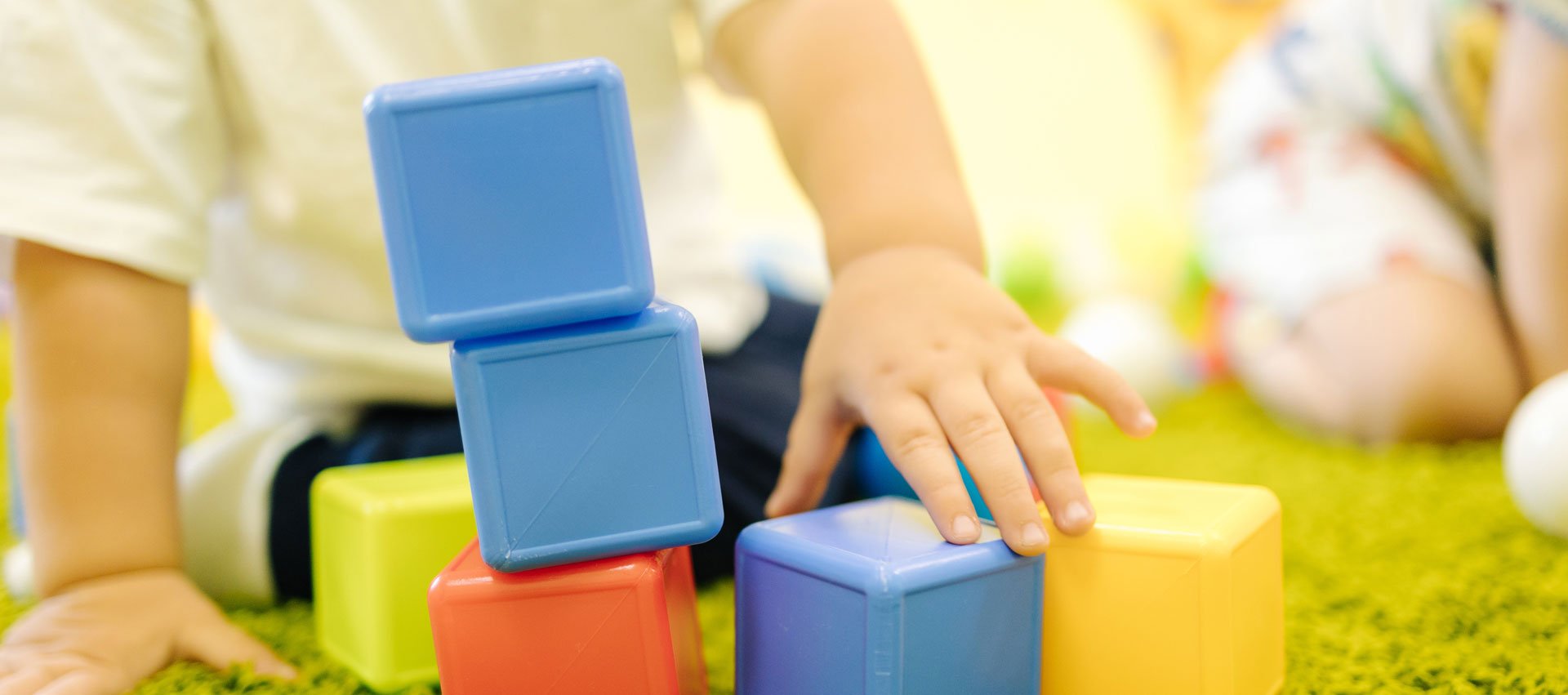 little-boy-builds-tower-cubes-kindergarten