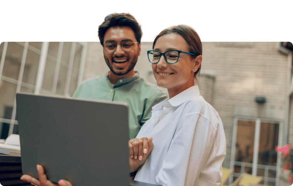 two-coworkers-smiling-looking-at-laptop