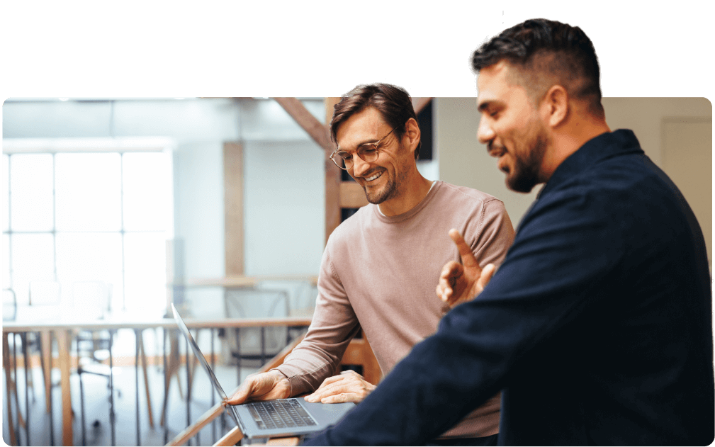 two-happy-coworkers-looking-at-laptop