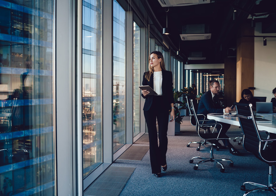 business-woman-looking-out-window-in-modern-office