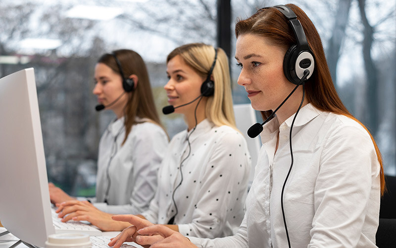 colleagues-working-together-call-center-with-headphones-thumb