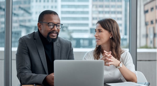 two-coworkers-reviewing-data-on-laptop